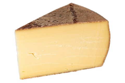 Freigestelltes Käsestück mit dunkelbrauner Naturrinde und cremig-gelbem Teig auf weißem Grund.