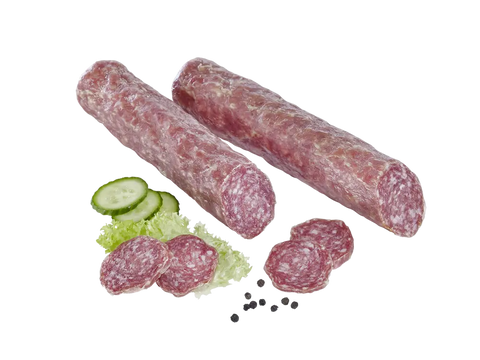 Zwei Salamistangen mit aufgeschnittenen Scheiben, Gurken, Salatblatt und Pfefferkörnern, freigestellt.