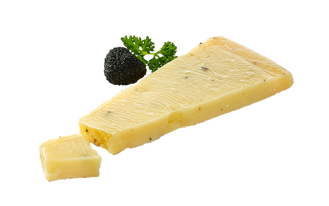 Keil Trüffelkäse mit schwarzen Sprenkeln, daneben Trüffelknolle und abgeschnittener Würfel