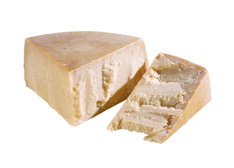 Kräftig gereifter Grana-Hartkäse mit goldener Rinde, ein keilförmiges Stück abgeschnitten, auf Weiß