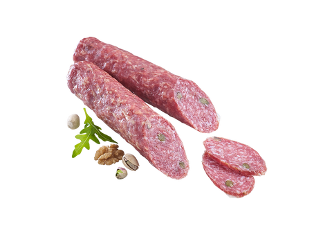 Salami mit sichtbaren Pistazien im Anschnitt, dekoriert mit Rucola, Walnuss und Pistazienkernen